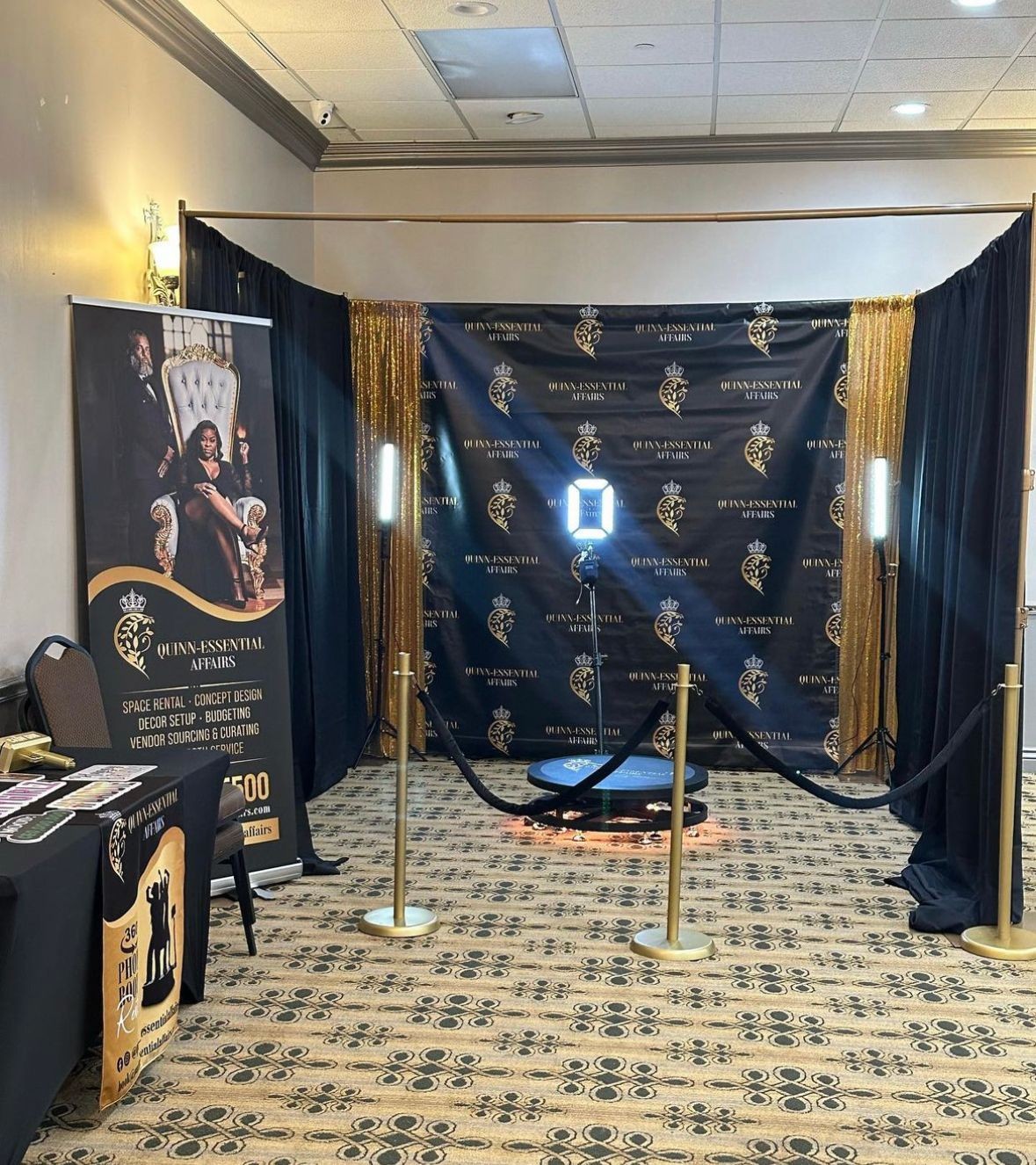 Event booth setup with backdrop, lighting, and promotional materials for Quinn-Essential Affairs.